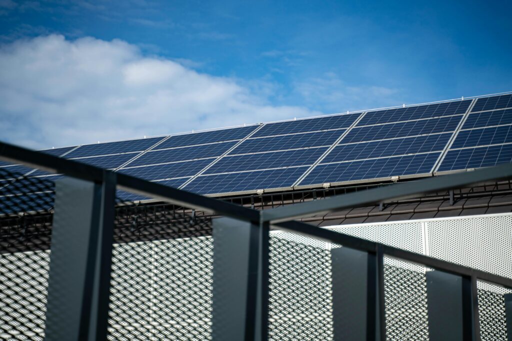 pexels-photo-13963757-13963757 Close-up view of modern solar panels on a rooftop against a clear blue sky, representing clean energy.